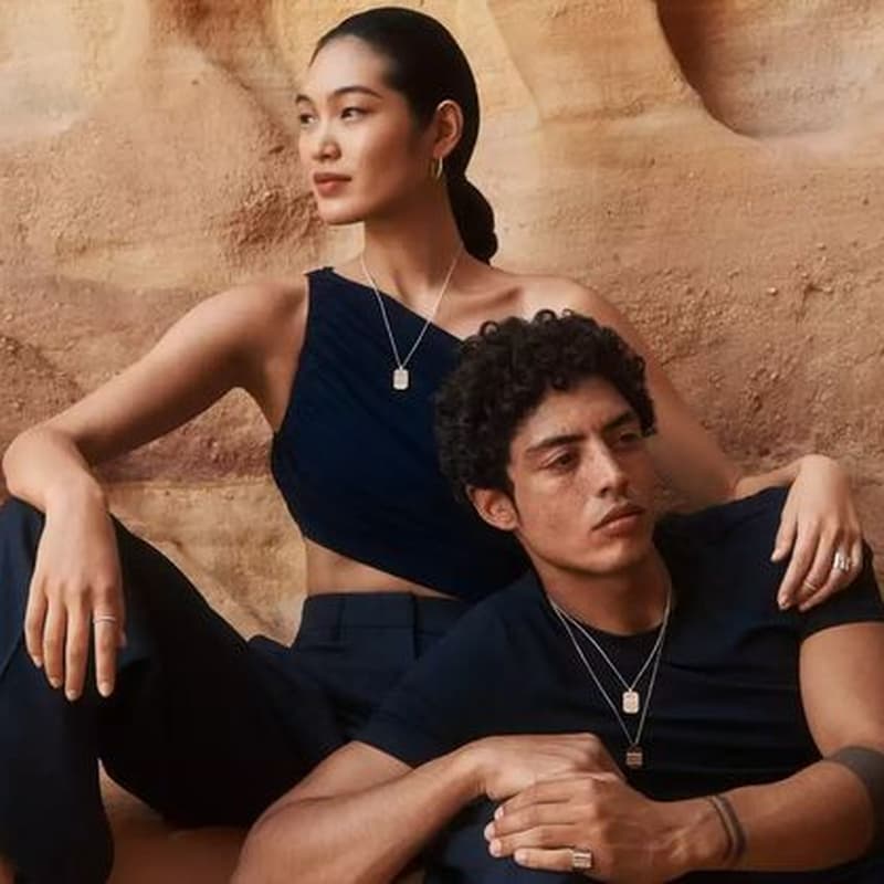 Two jewellery talent wearing dark blue outfits and diamond jewellery seated against sandstone formations in Wadi Rum.