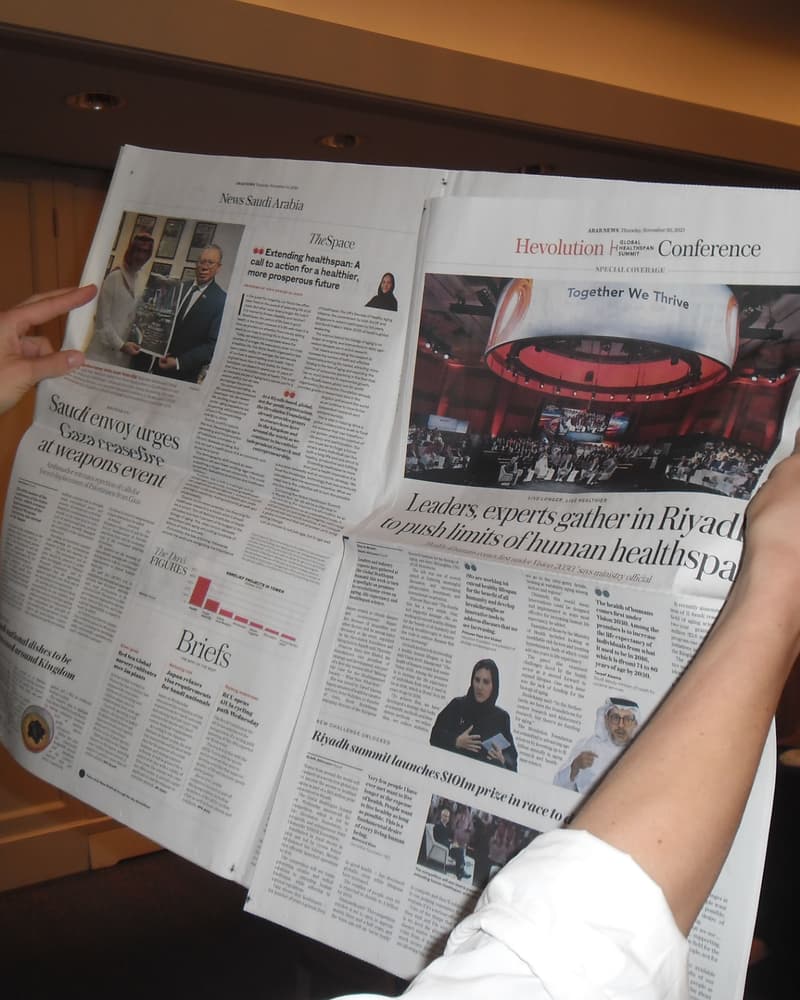 Printed newspaper coverage of a Riyadh summit showing a Global Healthspan Summit feature article and conference image.