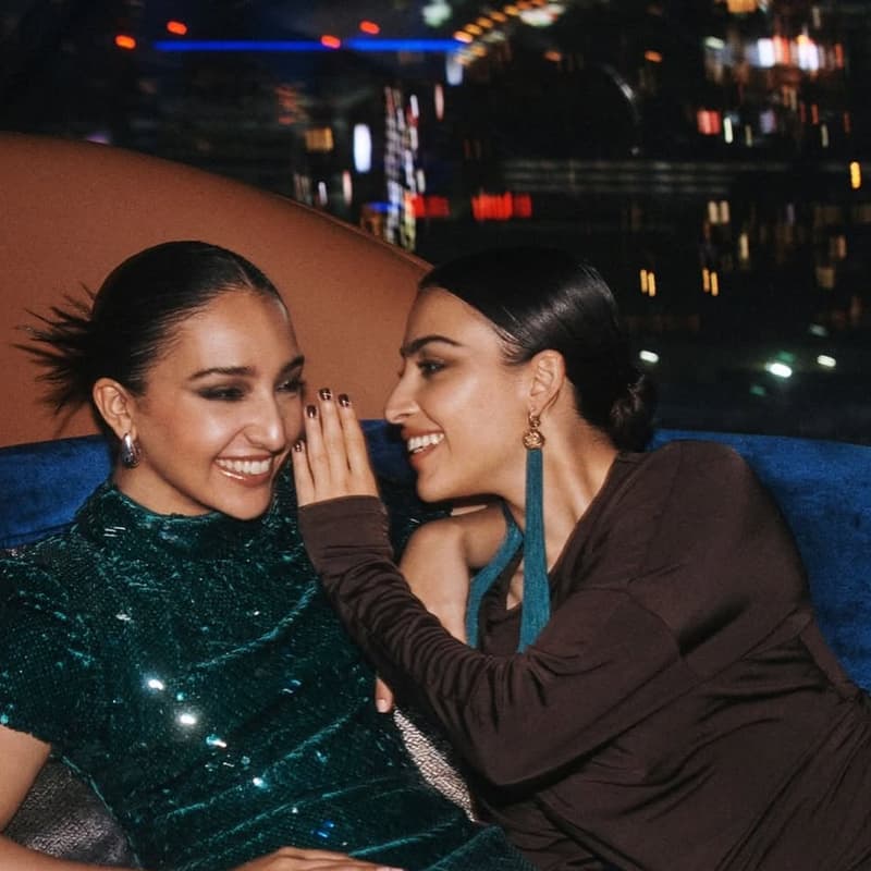 Two lifestyle talent seated together in a night hotel lounge setting with Dubai city lights behind them.