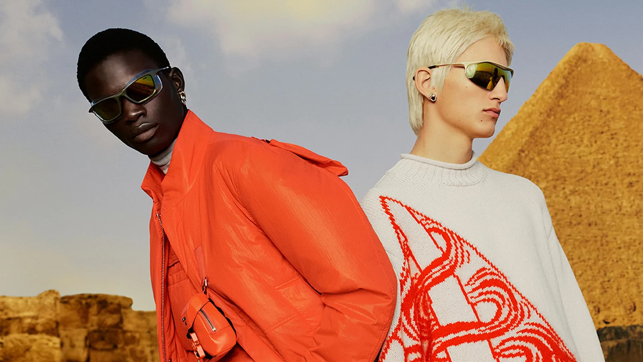 Dior Fall Men's Campaign fashion photography with three models wearing menswear, sunglasses, bags, and layered looks in front of the pyramids in Giza, Egypt.